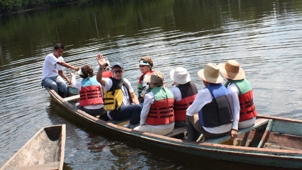 Grupo de turistas en tour en canoa por el río Amazonas